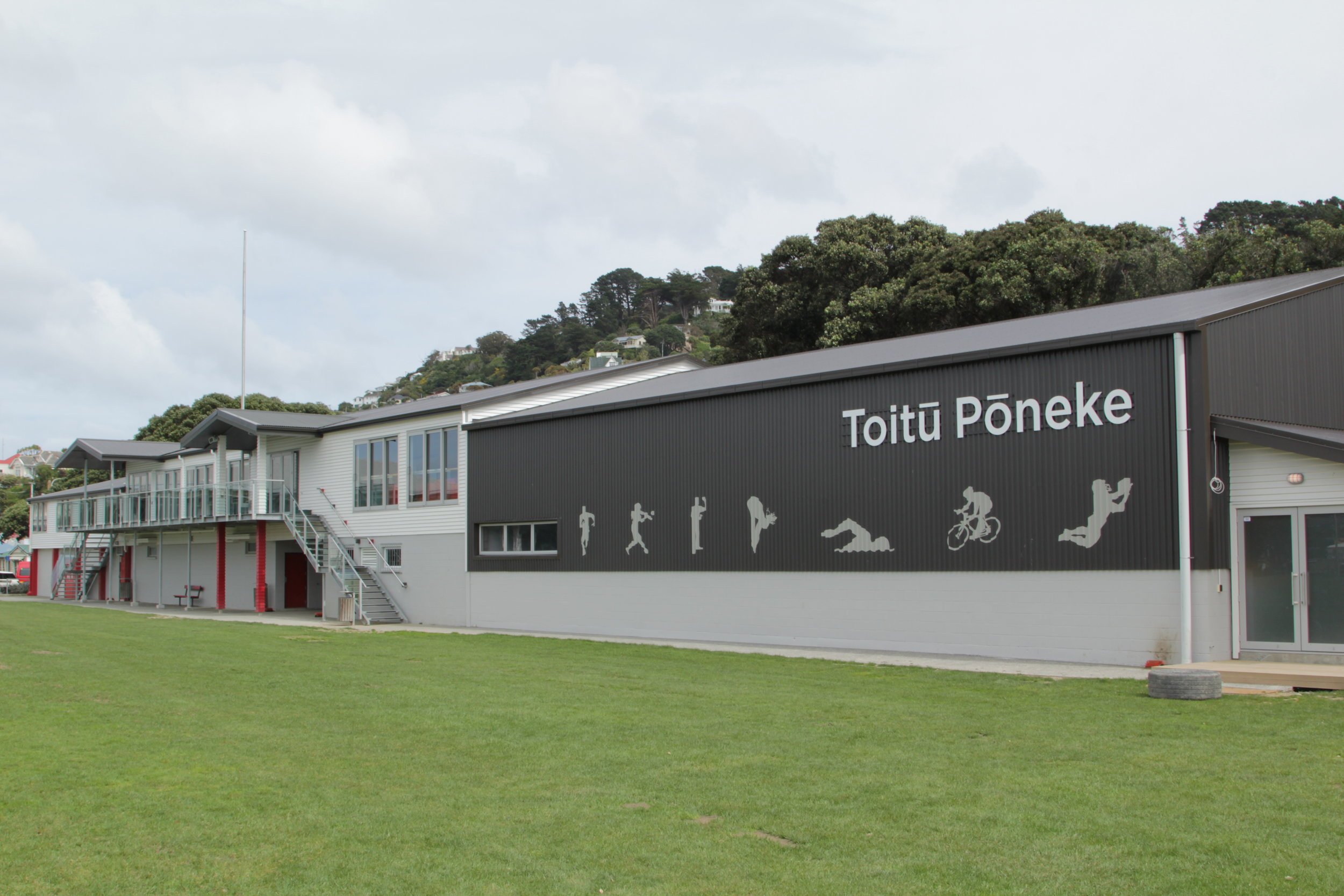 Toitū Pōneke overlooking the playing field, with its name on the building